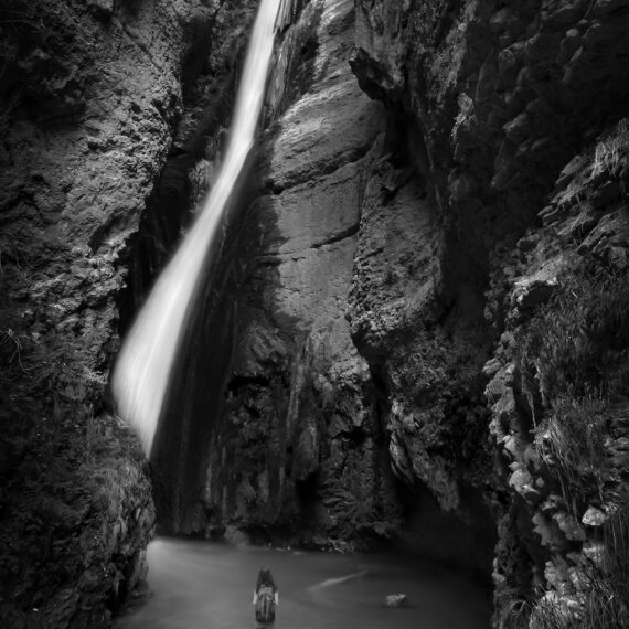 Woman standing close to waterfall France